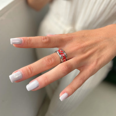 bague mood en argent avec des coeurs rouges portée par une femme habit blanc et ongles