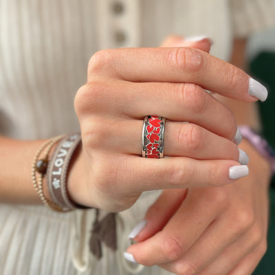 bague mood en argent avec des coeurs rouges portée par une femme habit blanc et ongles et bracelets