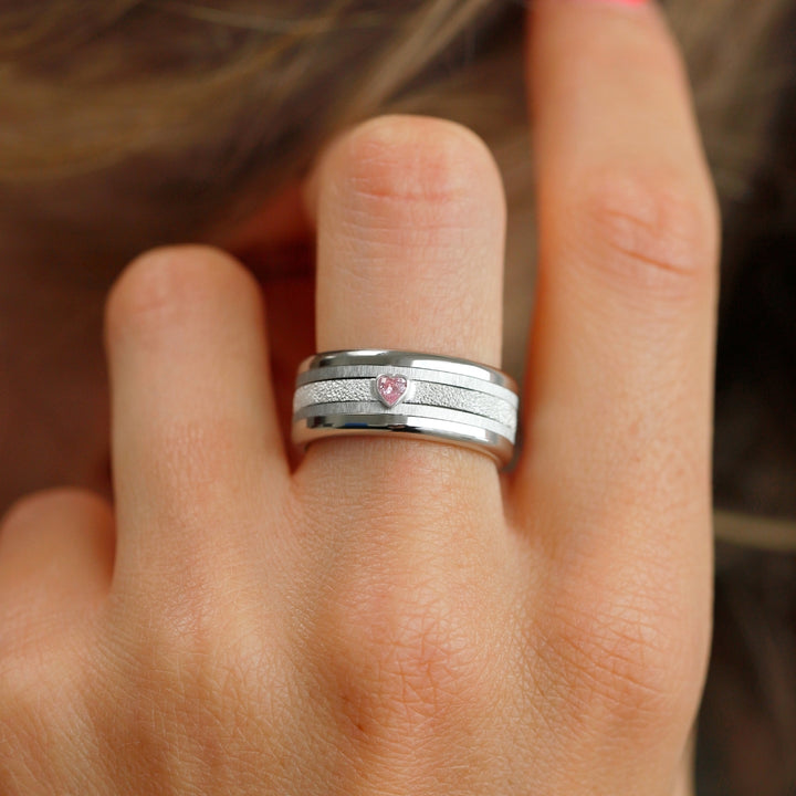 bague en argent avec brillant rose en forme de coeur et anneaux interchangeables en acier inoxydable de la marque mood sur main de femme