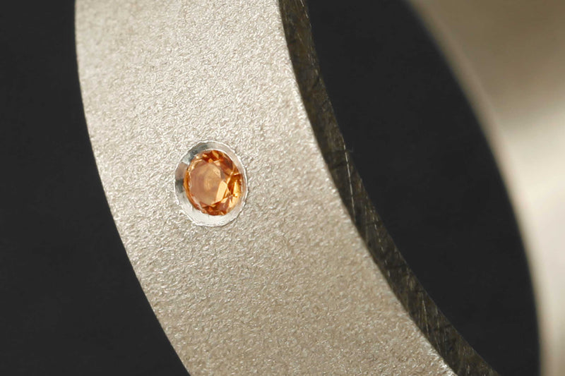 Setting of an orange Sapphire